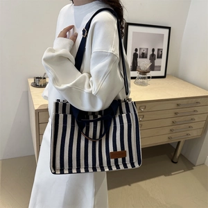 Striped canvas tote bag for women featuring navy blue and white patterns with leather patch