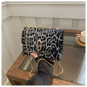 Detail of trendy leopard print handbag with golden oval metal lock and chain strap