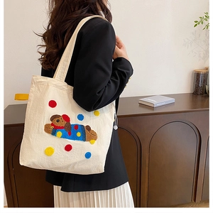 Détail du sac cabas en toile avec broderie chiot en peluche 3D et pois colorés vibrants