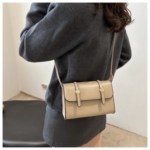 Vue détaillée du sac bandoulière kaki avec boucles dorées et lanières en cuir souple