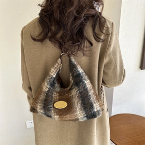Borsa hobo in peluche a scacchi con logo dorato e catena su un cappotto kaki