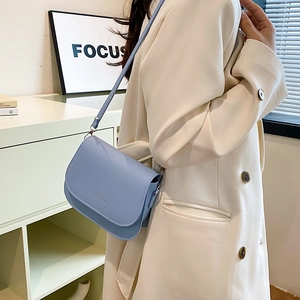 Minimalist light blue leather saddle bag for women with adjustable shoulder strap and flap