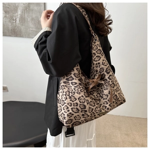 Dettaglio della borsa shopper leopardata con fiocco in pelle marrone e targhetta logo
