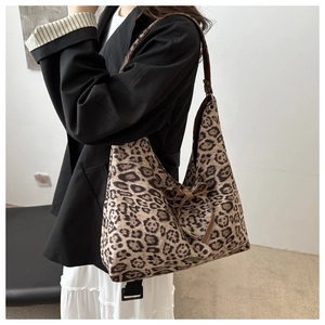 Dettaglio borsa tote leopardata con tracolle in pelle marrone e decorazione a fiocco