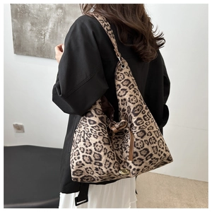 Detail of leopard print tote bag with leather bow and golden metal logo plate
