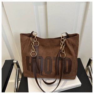 Close-up of brown suede tote bag with HOOTD patch and chain leather shoulder strap
