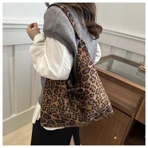 Dettaglio della borsa tote scamosciata leopardata con fiocco e logo in metallo