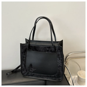 Détail du sac cabas noir avec application papillon et mélange de matières texturées