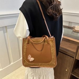 Sac fourre-tout marron en fausse fourrure et cuir avec broderie papillon sur mannequin