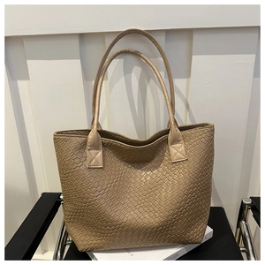 Macro shot of khaki woven faux leather texture on large capacity tote bag surface