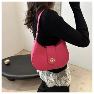 Close-up of a stylish rose pink hobo bag with gold twist lock and adjustable shoulder strap