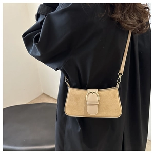 Dettaglio borsa baguette in camoscio beige con fibbia a ferro di cavallo dorata