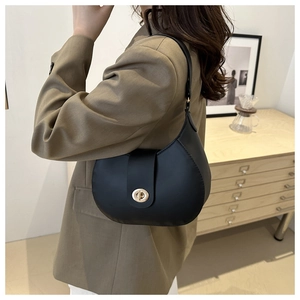 Side view of woman wearing a black crescent shoulder bag with golden ring lock