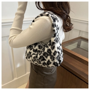 Close-up of soft leopard print faux fur shoulder bag with plush texture and half-moon shape