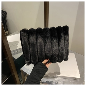 Detail der schwarzen Kunstpelz-Clutch mit weicher vertikaler Rippenstruktur und Wolkenform