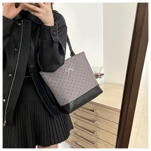 Mirror selfie showing the grey fabric tote bag with red hearts and black leather base