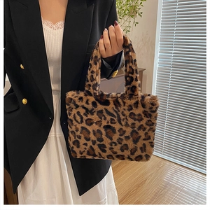 Detail der Handtasche aus Leoparden-Kunstpelz kombiniert mit schwarzem Blazer und Kleid
