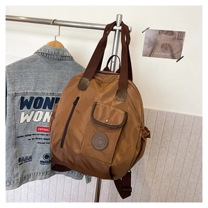 Detailed view of brown nylon travel bag featuring multi-pocket design and durable straps