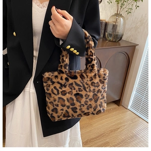 Detail einer Plüschtasche mit Leopardenmuster, handgehalten in gemütlichem Ambiente