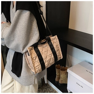 Détail du motif matelassé et des sangles contrastées noires sur le sac fourre-tout