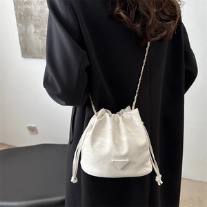 Minimalist white leather drawstring bucket bag with elegant chain strap for women
