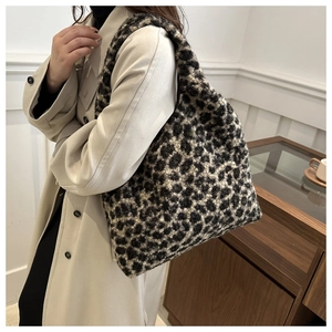 Vue latérale d'un grand sac cabas en peluche léopard porté avec un trench beige chic