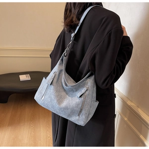 Detail of the light blue denim tote bag with side pocket and adjustable wide strap