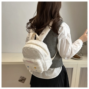 Detailansicht weißer Plüschrucksack mit FASHION-Stickerei und bunten Blumenapplikationen