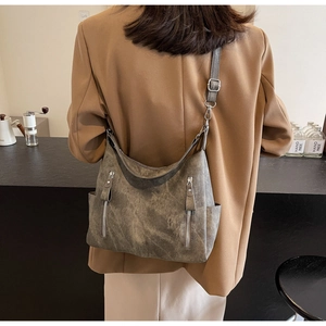 Back view of a model wearing the textured retro crossbody tote with multi-zipper pockets