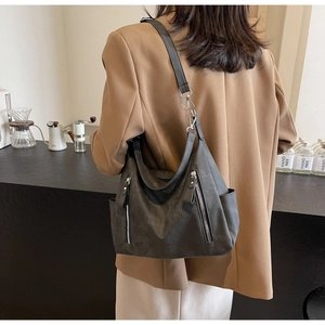 Charcoal grey matte suede tote bag shown with multi-zipper detail and side pockets