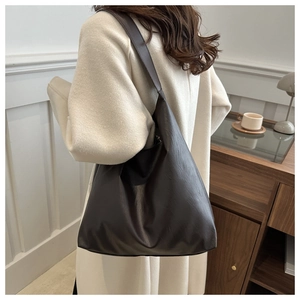 Detail of a dark brown PU leather tote bag showing large capacity and textured finish