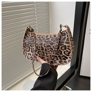 Detail of leopard print underarm bag shown with handle grip for size perspective