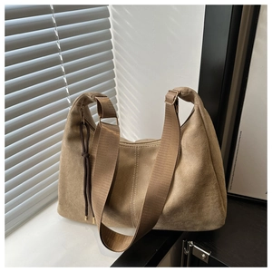 Close-up of khaki hobo tote bag featuring suede texture and woven shoulder strap details