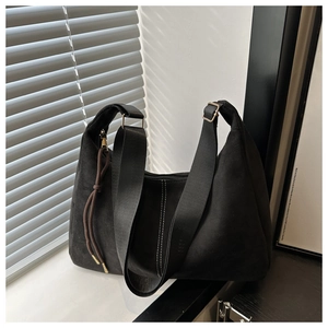 Detail of matte black tote bag with white contrast stitching and adjustable wide strap