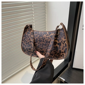 Detail of leopard print baguette bag with gold-tone hardware and crescent moon shape