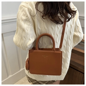 Vue détaillée du sac à main carré caramel avec inscription mode et petit porte-monnaie