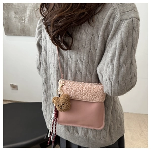 Sac seau rose en imitation peau de mouton avec un charm ours porté par un mannequin
