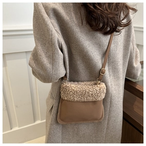 Détail d'un sac bandoulière en sherpa avec texture pelucheuse et sangle en cuir marron