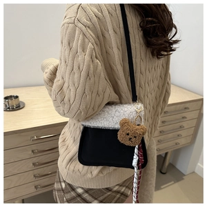 Détail du sac seau contrasté avec rabat en polaire blanche et pendentif ours mignon