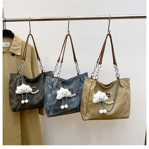 Detailed canvas tote bags in charcoal, blue, and khaki with decorative charms and pendants