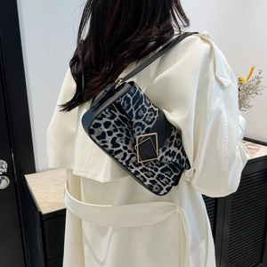 Fashionable leopard print underarm bag with gold metal buckle shown on a model