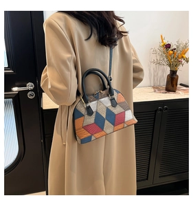 Fashion shell bag with geometric color-block pattern shown on a trench coat model