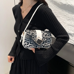 Leopard print crossbody bag with white stripe and shoulder strap on black knitwear