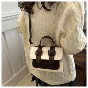 Detail of color-block crossbody bag styled with a cream sweater for a cozy look