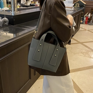 Sac bandoulière en cuir grainé gris avec clous dorés et bandoulière réglable