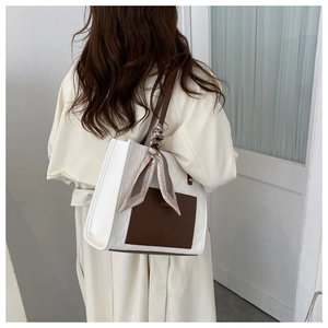 Detail of white plaid tote bag with brown pocket and silk scarf on model