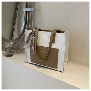 Detail of checkered tote bag with brown leather pocket and silk scarf decoration