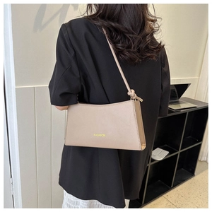 Détail du sac à épaule en cuir marron clair avec texte FASHION jaune et bandoulière nouée