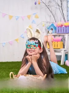 Detail view of a child wearing light blue Easter party glasses with rabbit and egg motifs