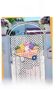 Easter wooden door sign with bunny and cart full of eggs hanging on a white gate